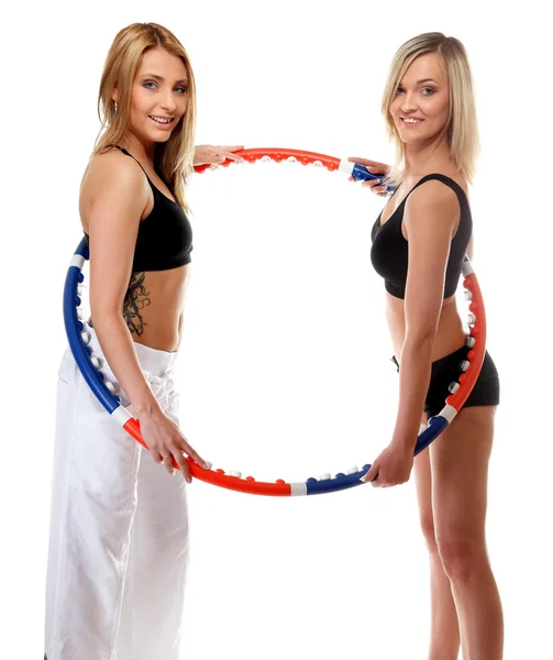 Two girls exercising with hula hoops in gym — Stock Photo, Image