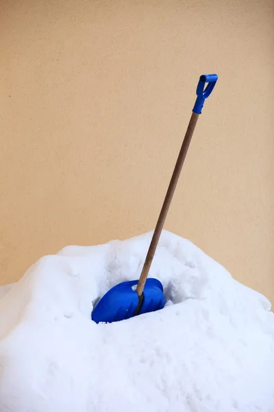 Pá de neve azul de pé na neve profunda — Fotografia de Stock