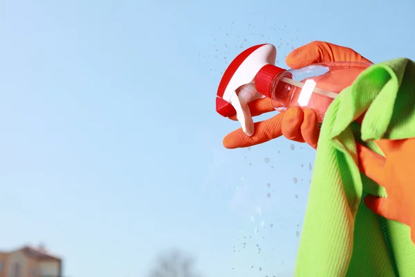 Gehandschoende hand schoonmaken van venster lap en spray — Stockfoto