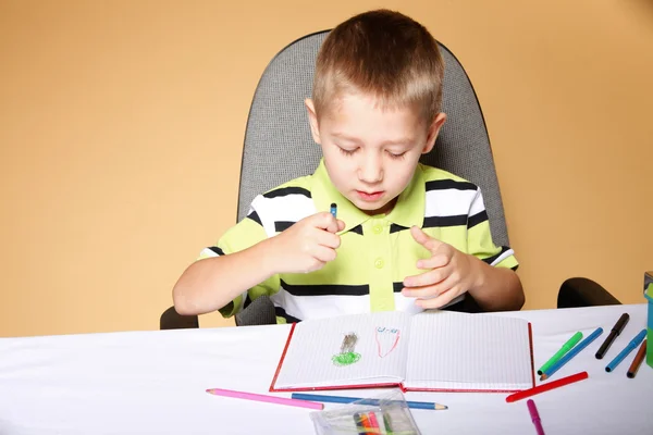 Young cute boy draws with color pencils Stock Photo