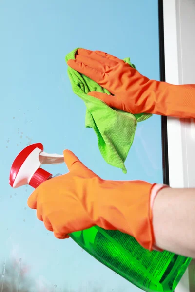 Behandschuhte hände putzen fenstertuch und spray — Stockfoto