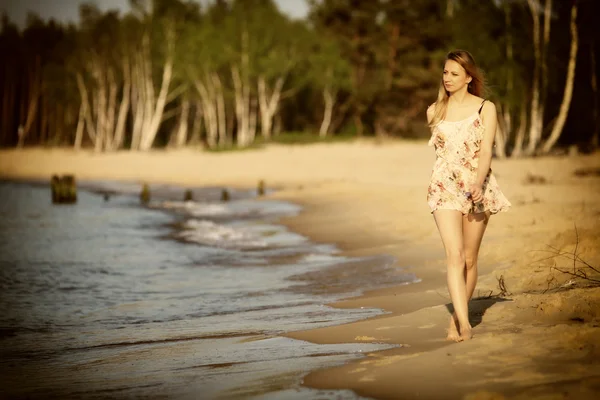 Jeune femme marchant sur une plage de sable fin — Photo