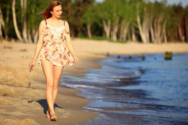 Young woman walking on a sandy beach — Stock Photo, Image