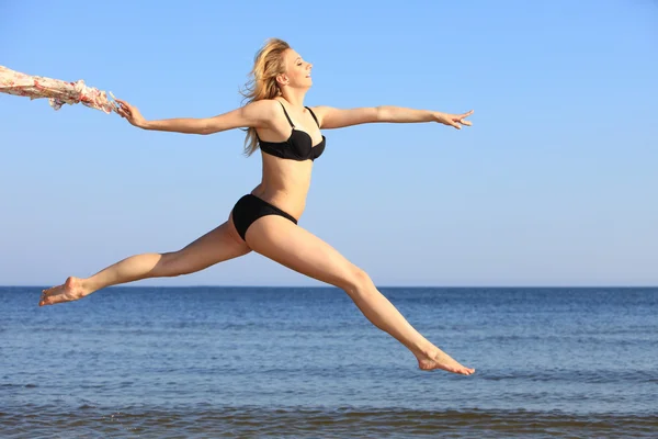 Young woman jumping on beach fit sporty girl — Stock Photo, Image