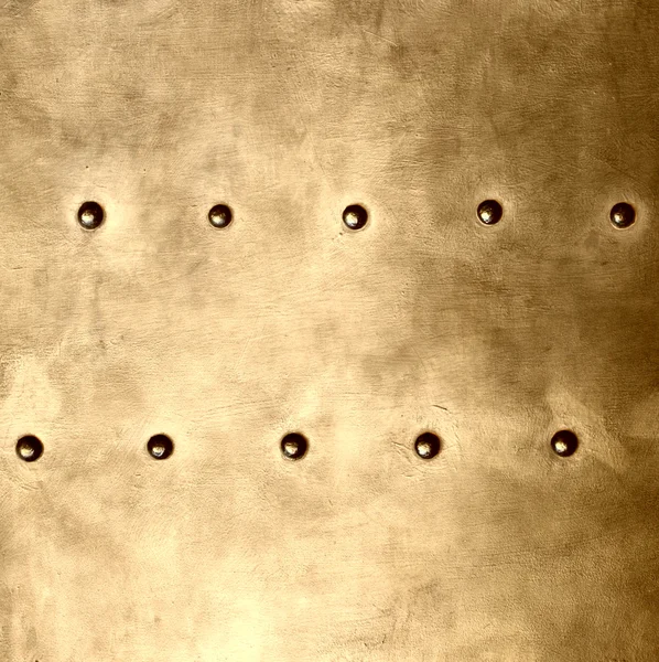 Gold metal plate or armour texture with rivets — Stock Photo, Image