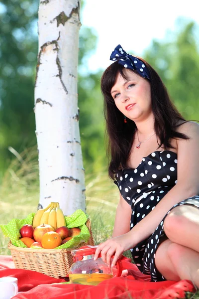 Piknik. piękna kobieta siedzi na koc — Zdjęcie stockowe