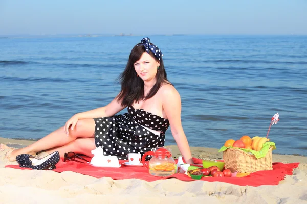 Un picnic. Bella donna seduta sulla coperta — Foto Stock