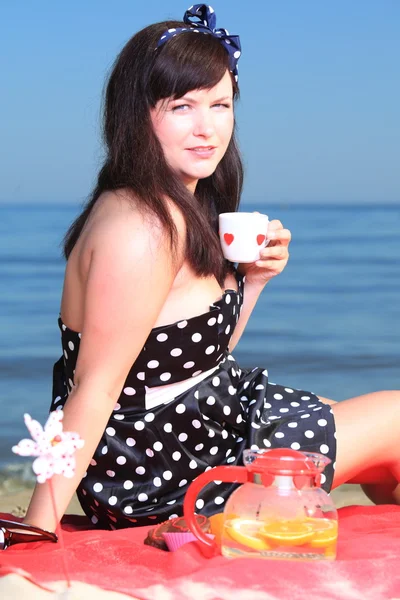 Picknick. schöne Frau sitzt auf der Decke — Stockfoto