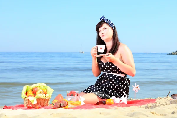 Un picnic. Bella donna seduta sulla coperta — Foto Stock