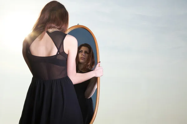 Femme réfléchie regarde le reflet dans le miroir — Photo