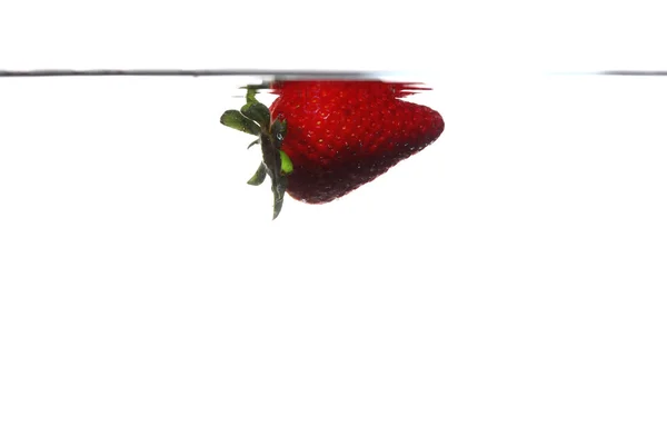 Erdbeere im Wasser spritzt über Weiß — Stockfoto
