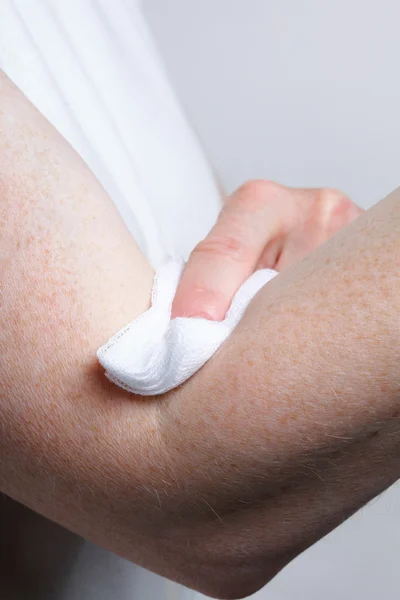 Pegar un hisopo a un brazo después de la muestra de sangre —  Fotos de Stock