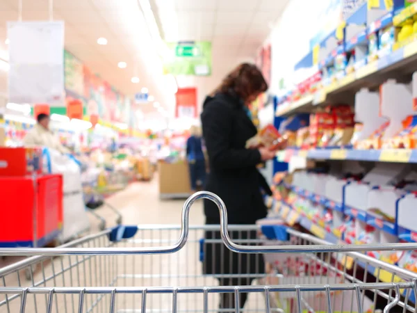 Mulher no supermercado com carrinho — Fotografia de Stock