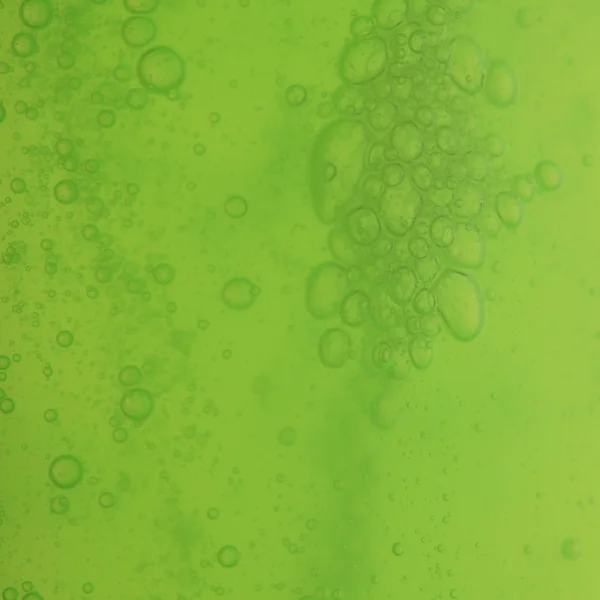 Bolle di sapone verde fondo liquido — Foto Stock