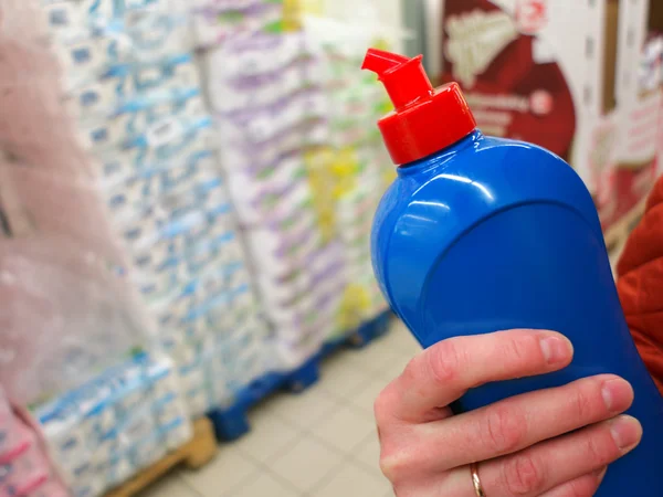 Female hand in store with detergent — Stockfoto