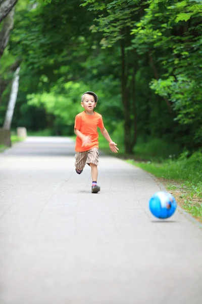 Ragazzo calci la palla in parco all'aperto — Foto Stock