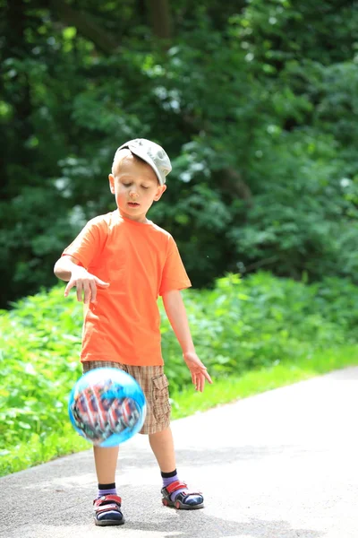 Pojke leker med boll i parken utomhus — Stockfoto