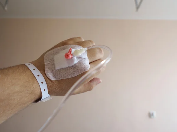 Hand van de patiënt in het ziekenhuis met een infuus — Stockfoto