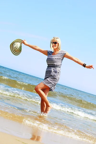 Reife Frau im Sommerurlaub am Strand — Stockfoto
