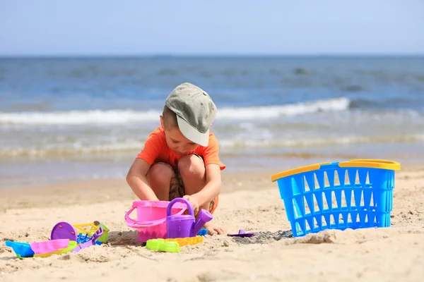 Хлопчик грає в іграшки на пляжі — стокове фото