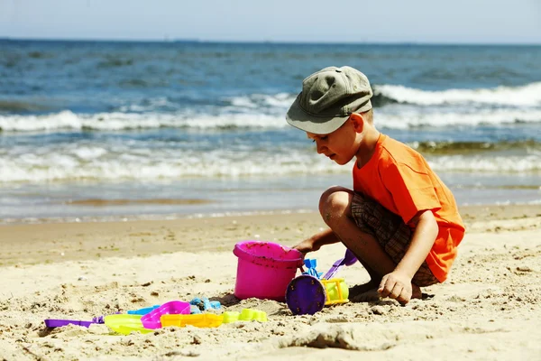 Garçon jouant des jouets sur la plage — Photo