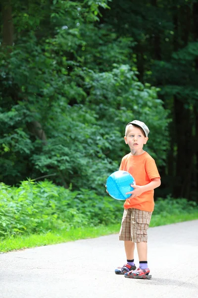 Garçon jouer avec la balle dans le parc à l'extérieur — Photo