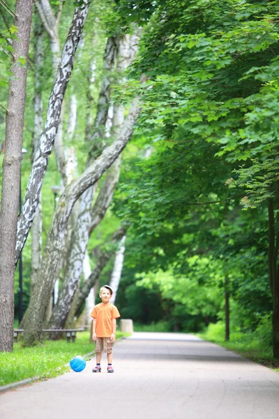 Ragazzo che gioca con la palla in parco all'aperto — Foto Stock