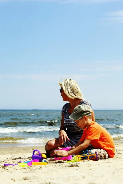 Son and mother playing toys on beach Royalty Free Stock Images