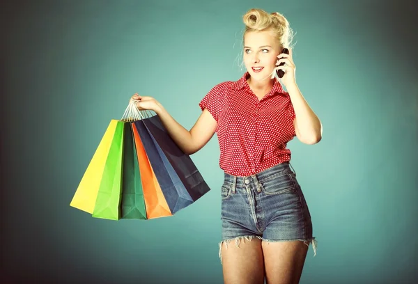 Meisje met shopping tassen en mobiele telefoon retro stijl — Stockfoto