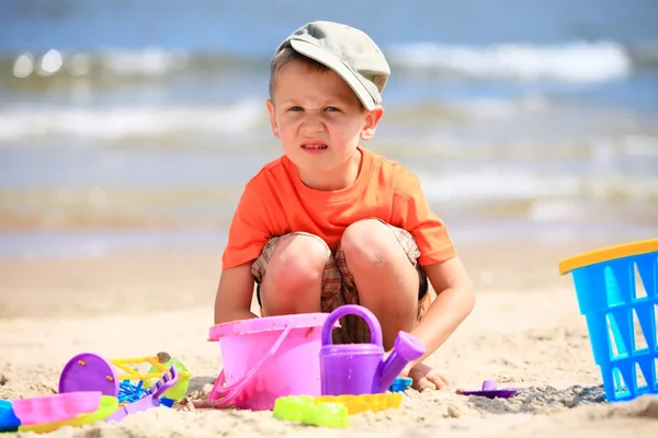 Pojke spela leksaker på stranden — Stockfoto