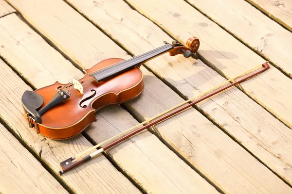 Geige auf Holzpfeiler. Musikkonzept — Stockfoto