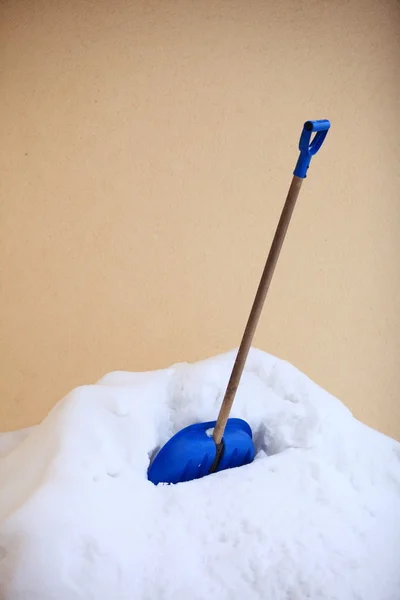 Pá de neve azul de pé na neve profunda — Fotografia de Stock