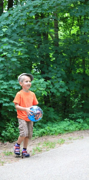 Menino brincando com bola no parque ao ar livre — Fotografia de Stock