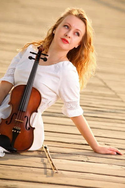 Het blonde meisje met een viool buiten — Stockfoto