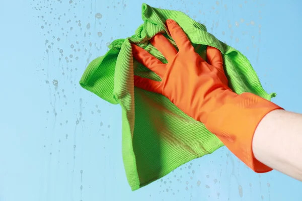 Gloved hand cleaning window with rag — Stock Photo, Image