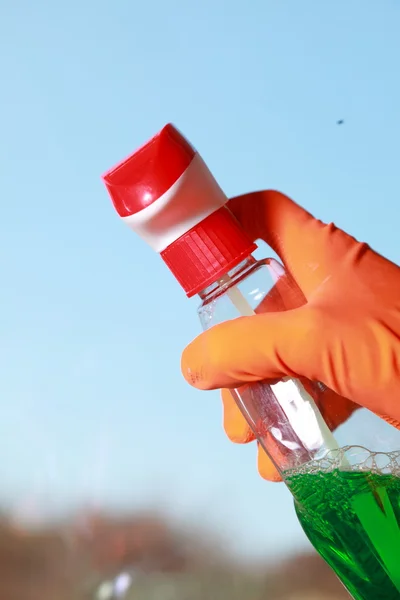 Behandschuhte hände putzen fenstertuch und spray — Stockfoto