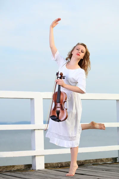 Het blonde meisje met een viool buiten — Stockfoto
