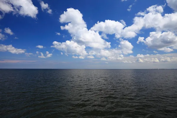 Ciel bleu nuageux au-dessus d'une surface de la mer — Photo