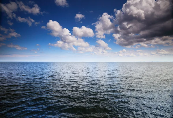 Bulutlu mavi gökyüzü denizin yüzeyinde — Stok fotoğraf