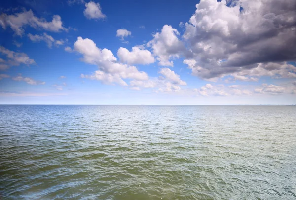 Zatažená modrá obloha nad hladinou moře — Stock fotografie