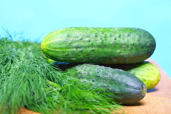 Bunch fresh dill and cucumbers on wooden table — Stock Photo, Image