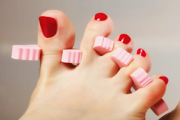 Pedicure del piede applicando unghie rosse — Foto Stock