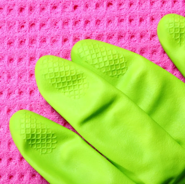 Розовая губка и зеленая резиновая перчатка — стоковое фото