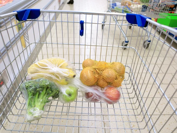 Carrito de compras con comestibles en el supermercado — Foto de Stock