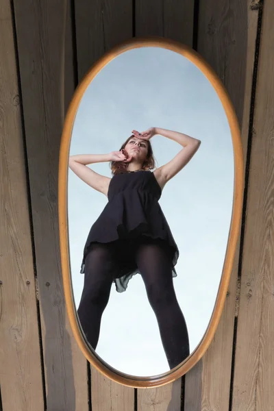 Doordachte vrouw met haar reflectie in spiegel — Stockfoto