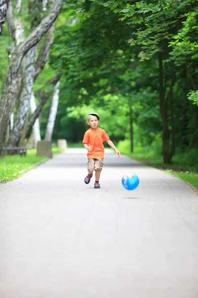 Boy kicks the ball in park outdoors — Stock Photo, Image