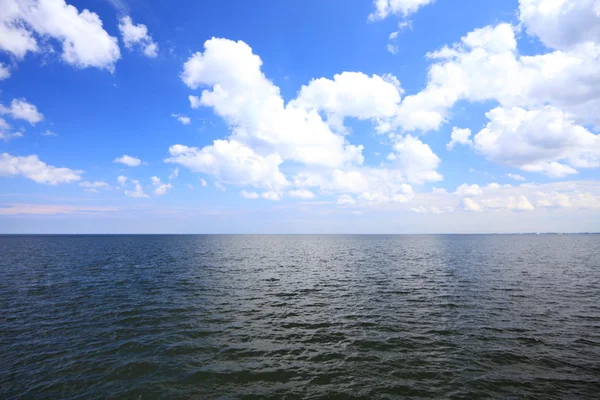 Cielo azul nublado sobre una superficie del mar —  Fotos de Stock