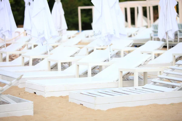 Белый бассейн стулья на песчаном пляже — стоковое фото