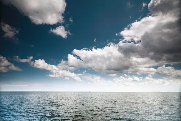 Zatažená modrá obloha nad hladinou moře — Stock fotografie