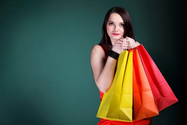 Jonge vrouw met papieren veelkleurige boodschappentas — Stockfoto